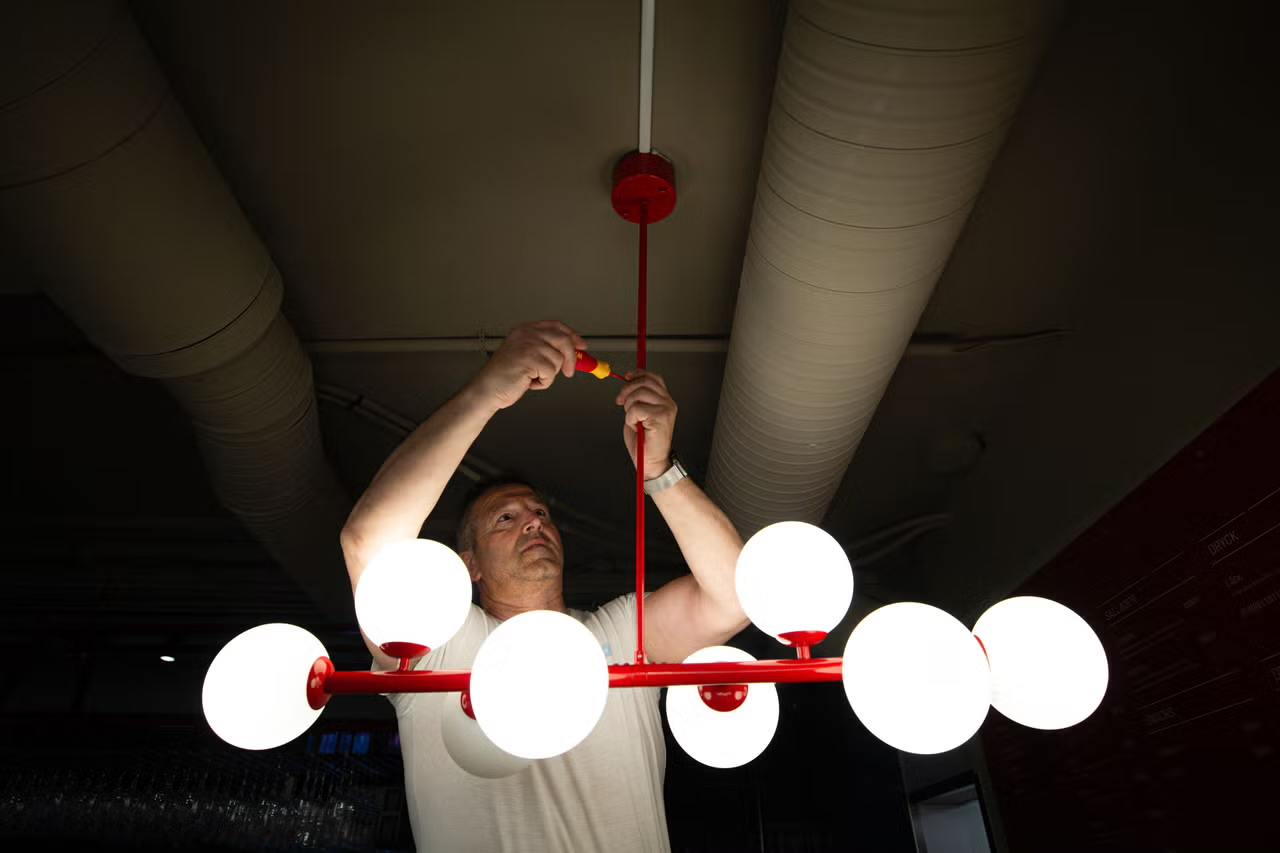 Elektriker som monterar takbelysning